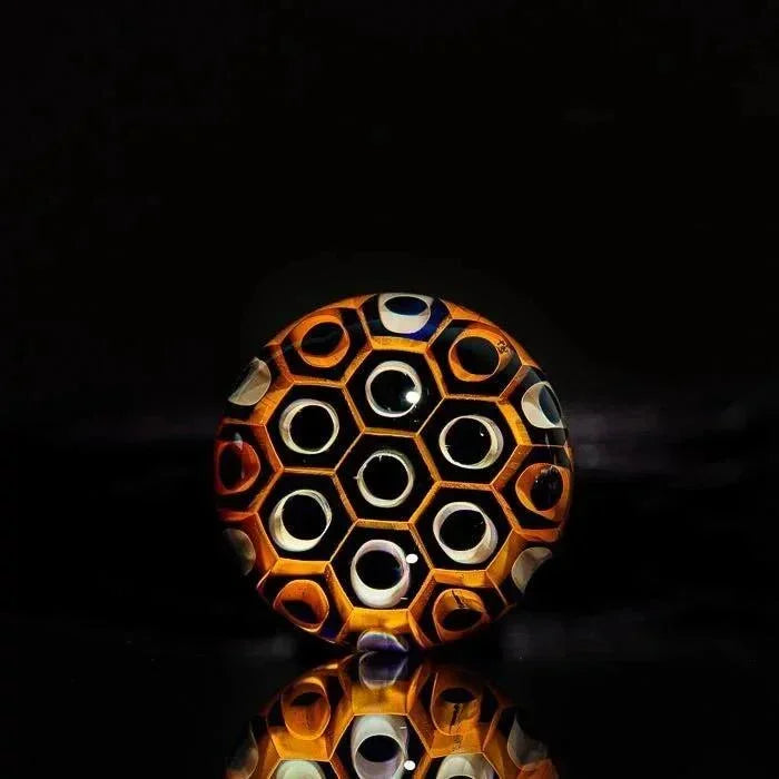 Hand-blown glass honeycomb sphere with amber and blue accents, reflective surface