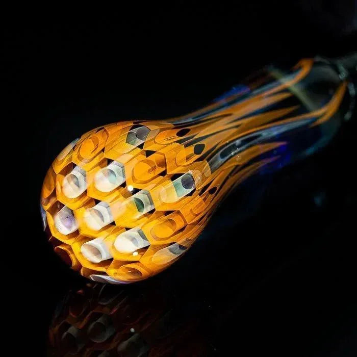 Vibrant orange honeycomb glass pipe with intricate design, perfect for heady glass collectors