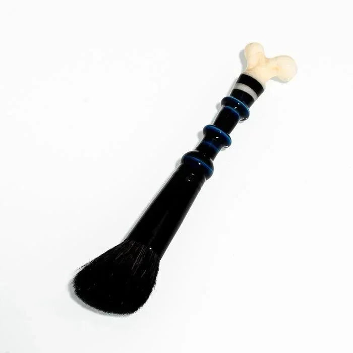 Black glass pipe with bone-shaped mouthpiece and blue accents, heady glass art piece