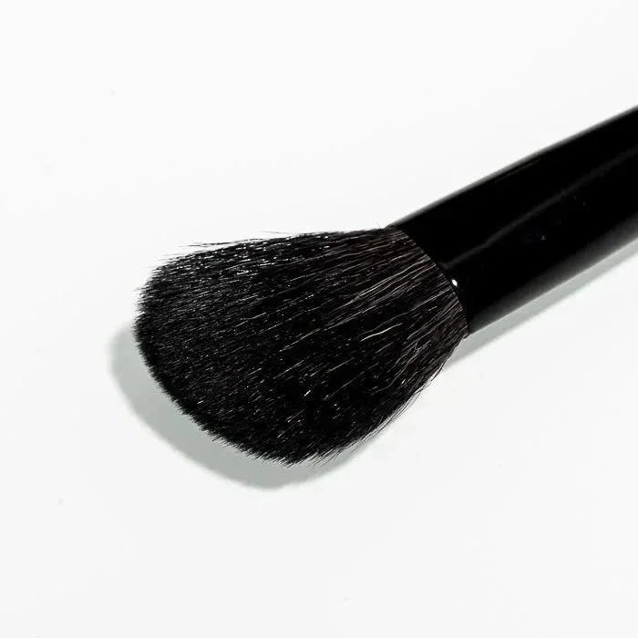 Black makeup brush with dense bristles on white background