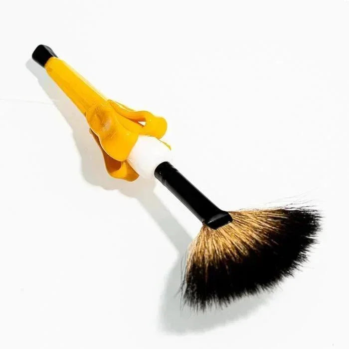 Yellow banana-shaped brush with black bristles, playful design for cleaning glass pipes or vaporizers