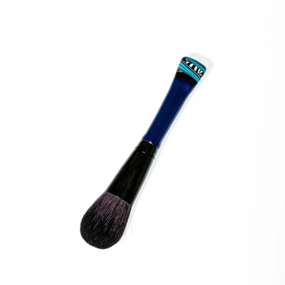 Blush makeup brush with a blue handle and decorative turquoise accent on white background
