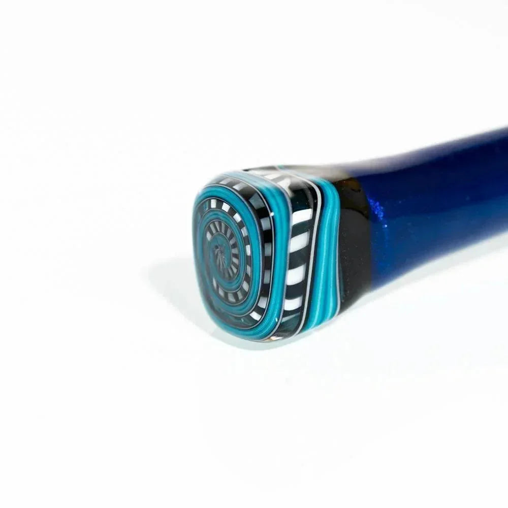 Close-up of a blue glass smoking pipe with a detailed patterned end, geometric black, white, and teal accents.