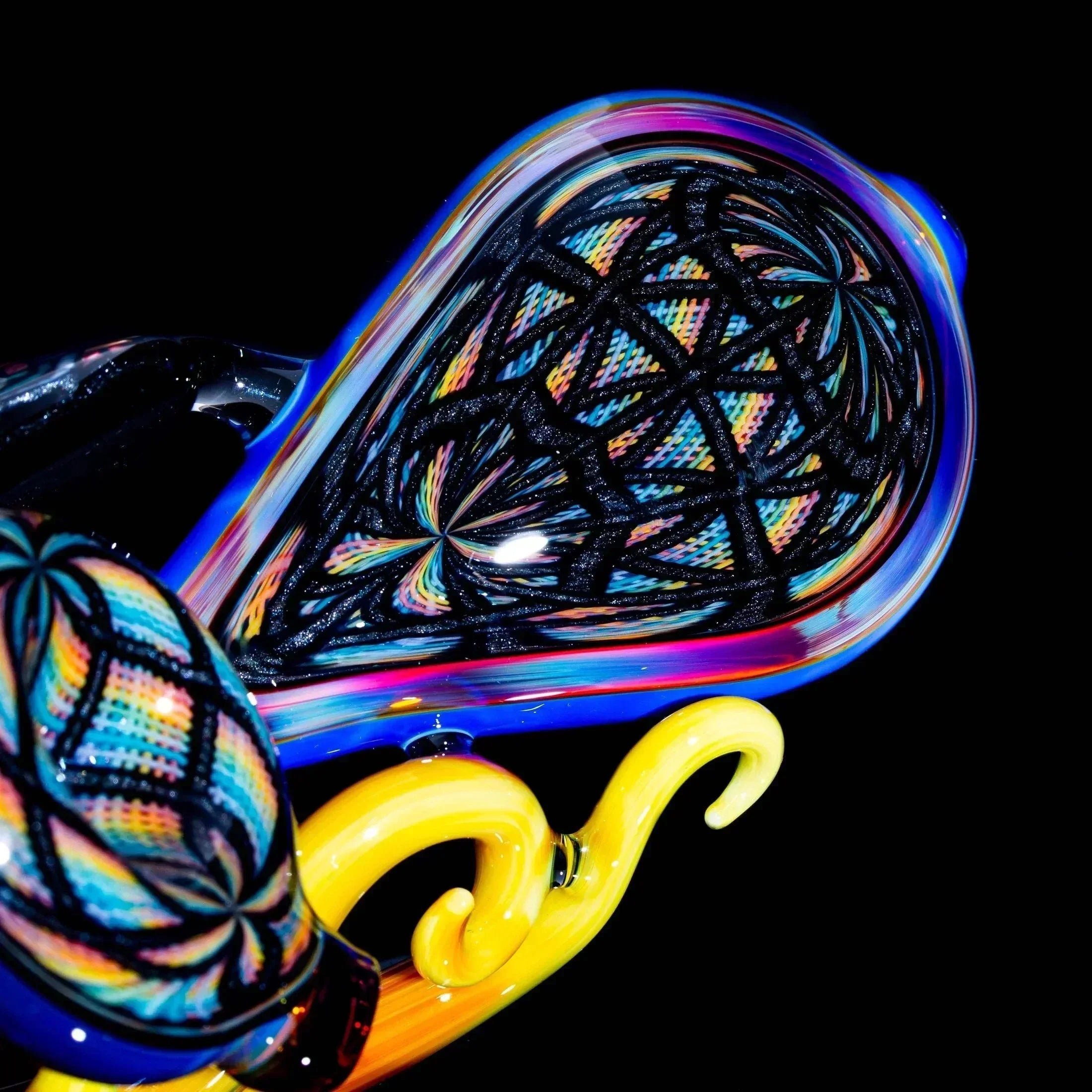 Colorful hand-blown glass pipe with intricate lattice and swirl patterns on black background