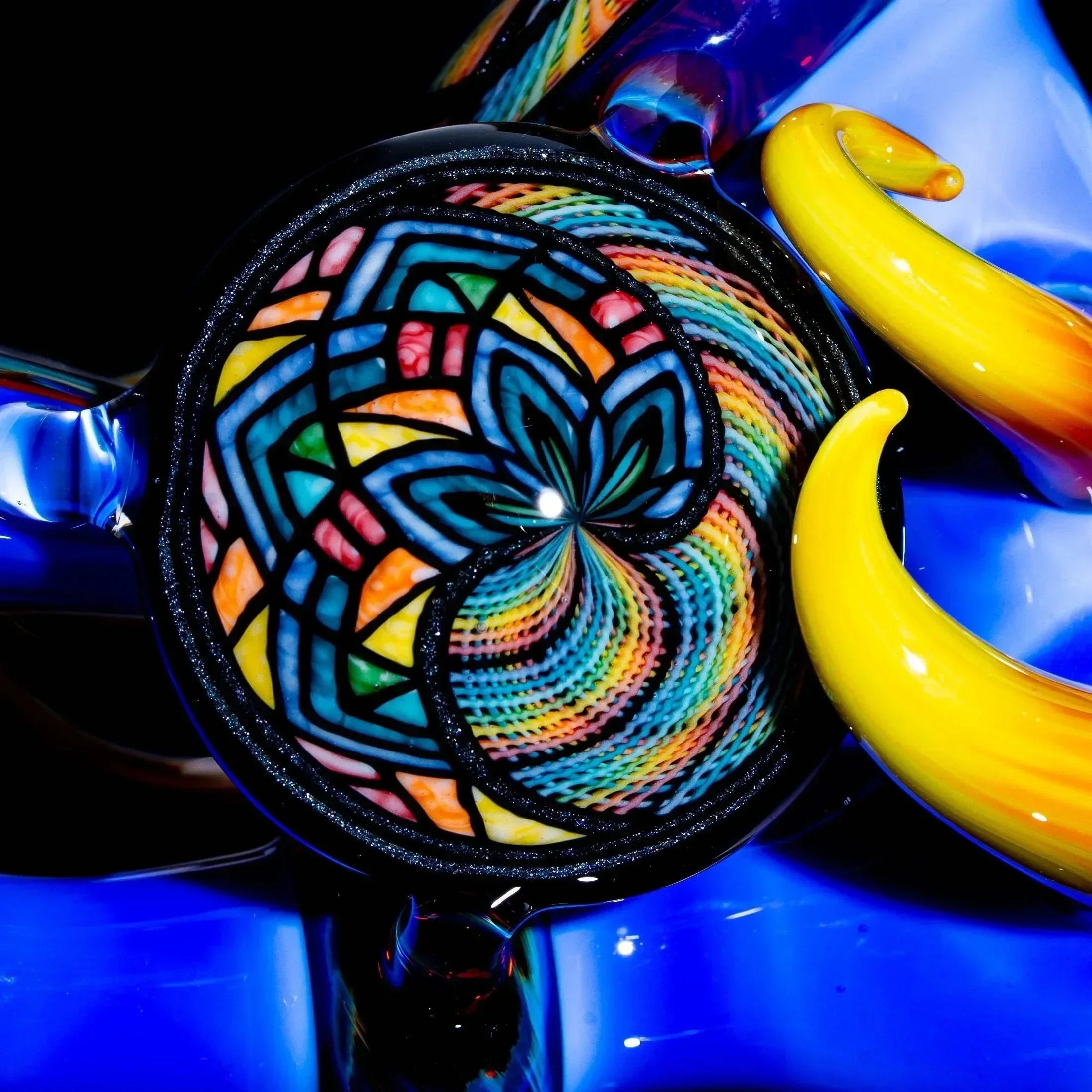 Colorful glass pipe with intricate lattice and retticello patterns, vibrant yellow and blue accents