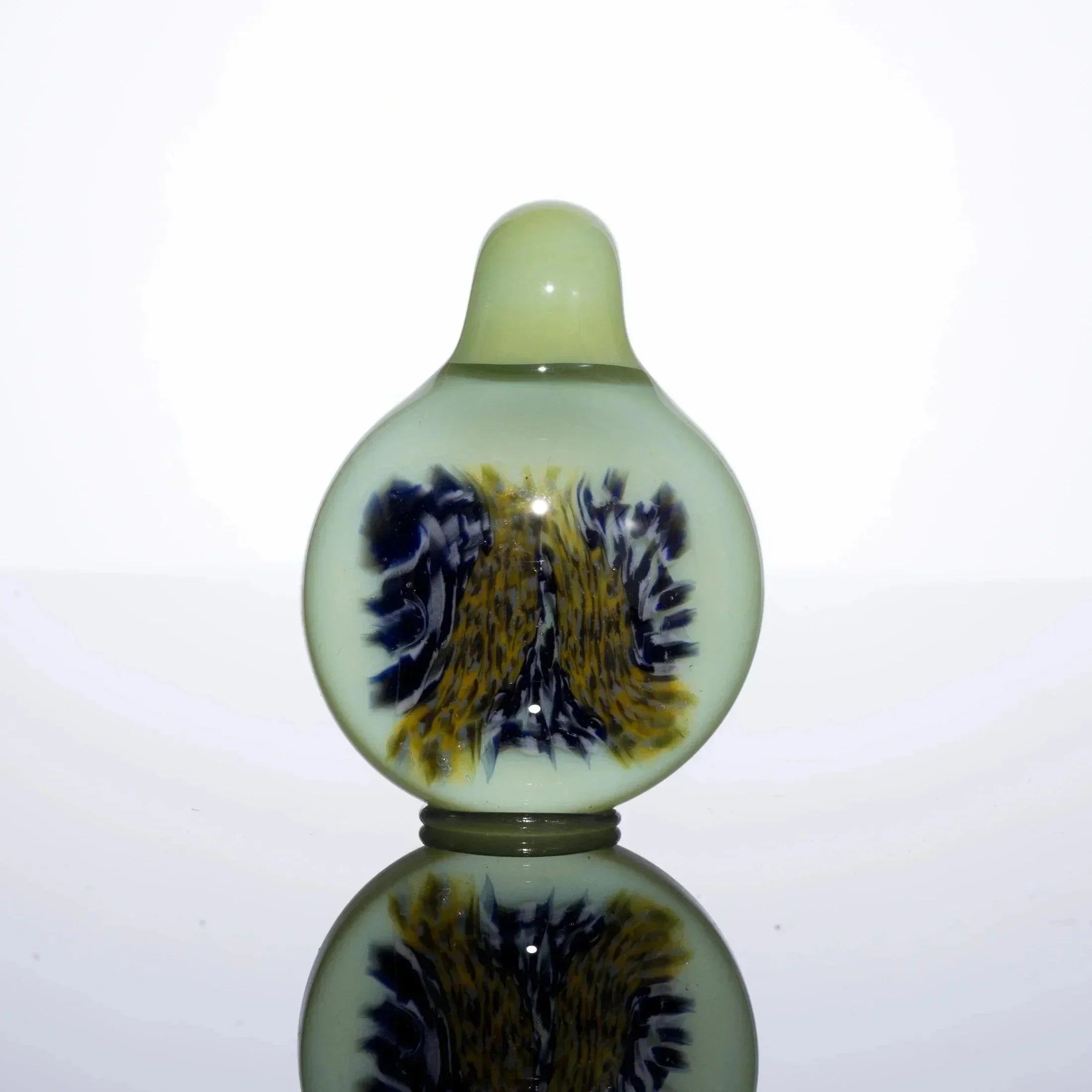 Handblown glass pipe with green base and blue-yellow swirl design, reflective surface