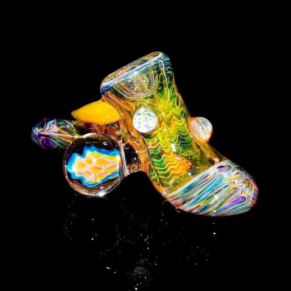 Colorful heady glass hand pipe with intricate patterns and marbles on black background