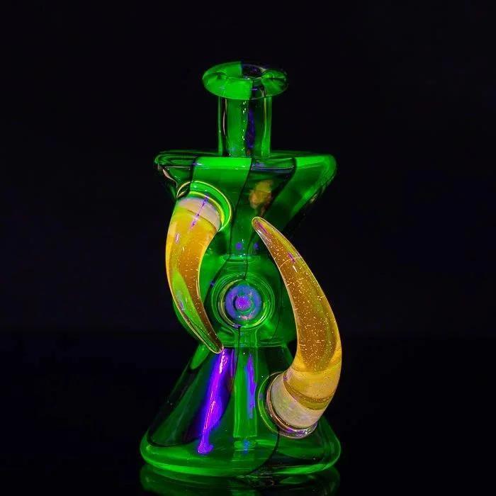 Vibrant green heady glass bong with amber horns and purple accents, glowing against black background