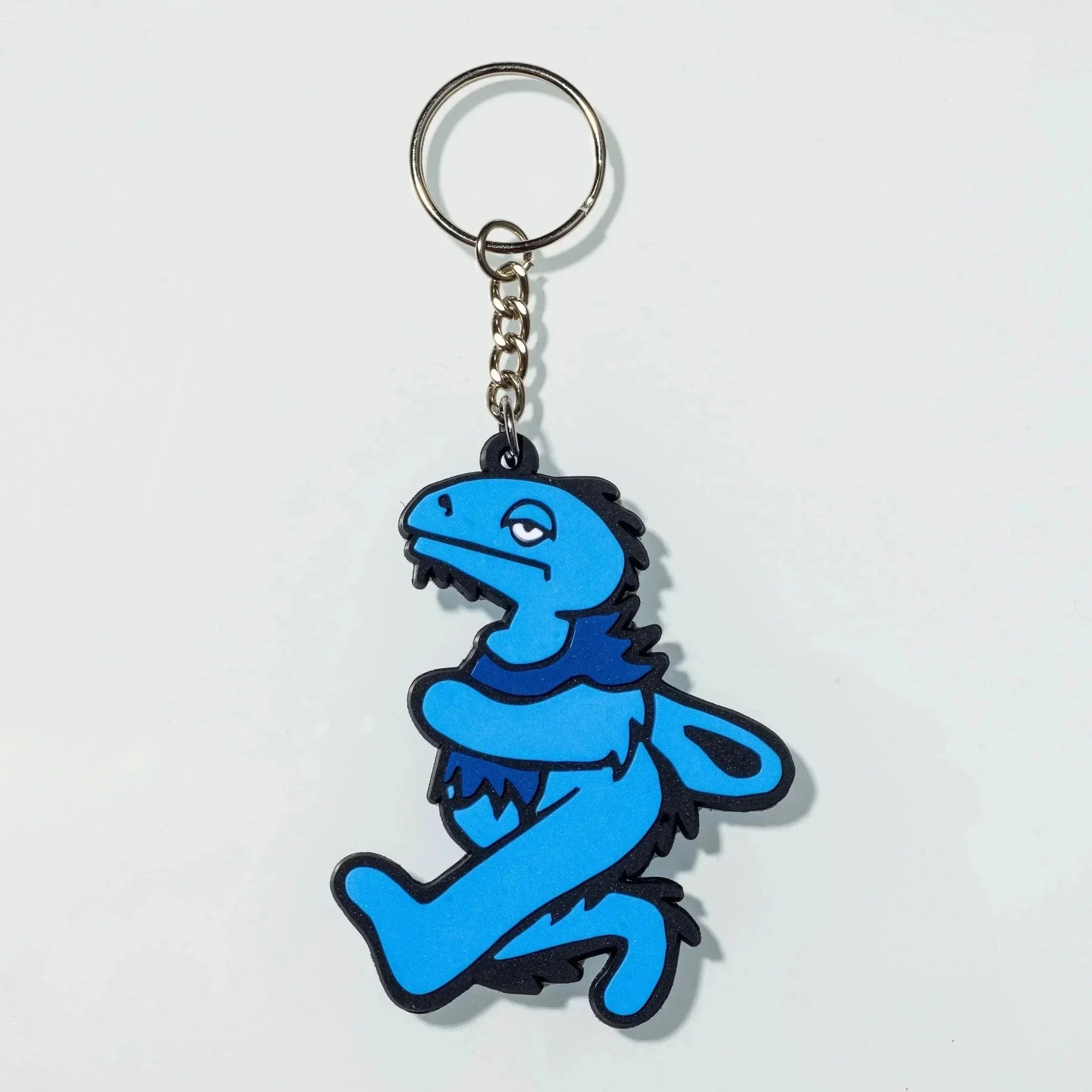 Blue dinosaur-shaped rubber keychain with black outline, attached to metal ring and chain