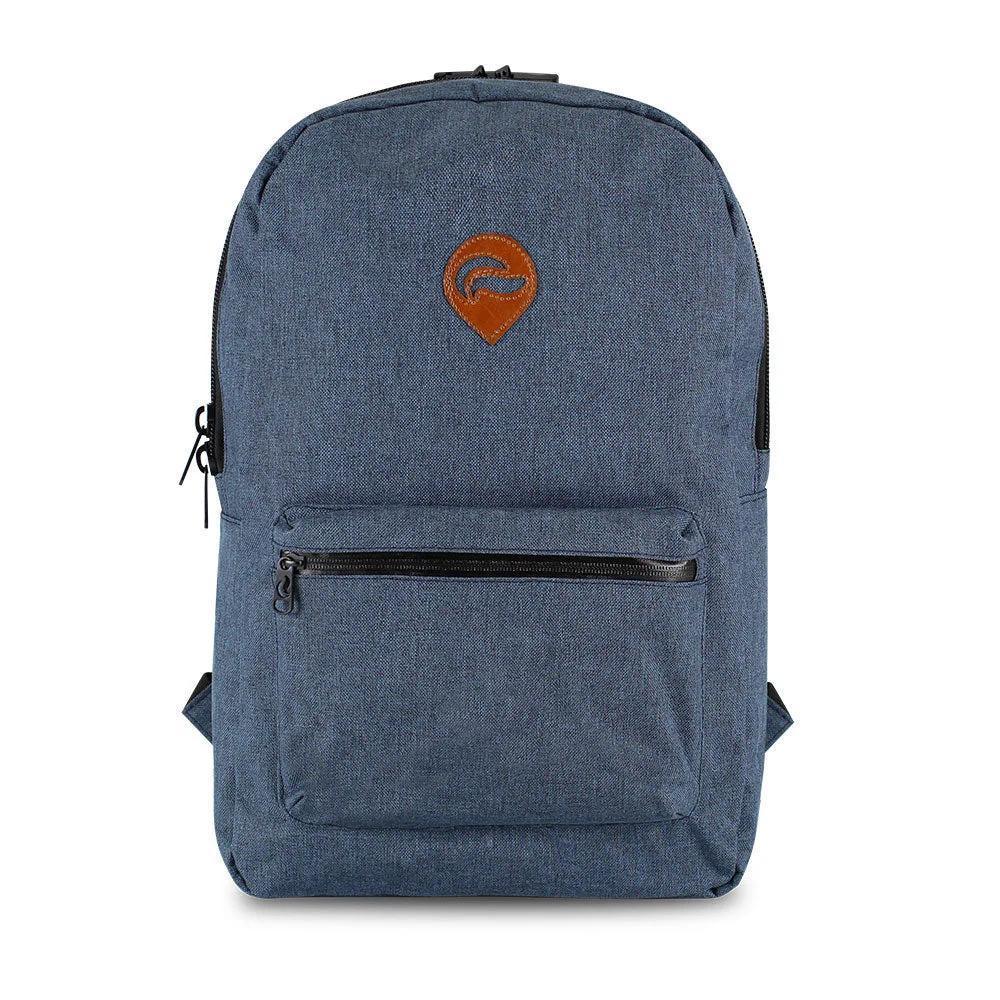 Denim blue backpack with front zip pocket and brown patch on plain background