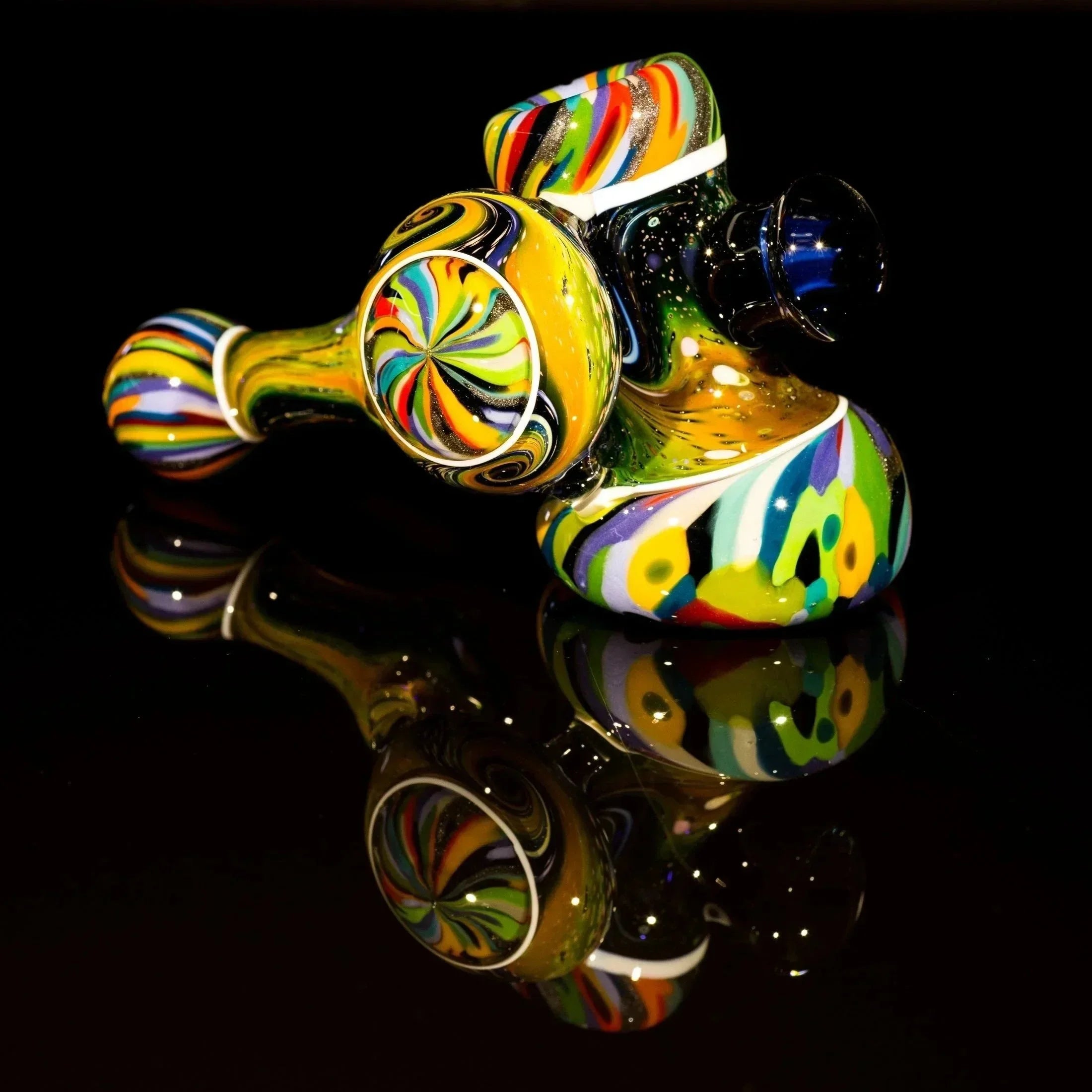 Vibrant, multi-colored heady glass pipe with swirls and galaxy accents on reflective black surface