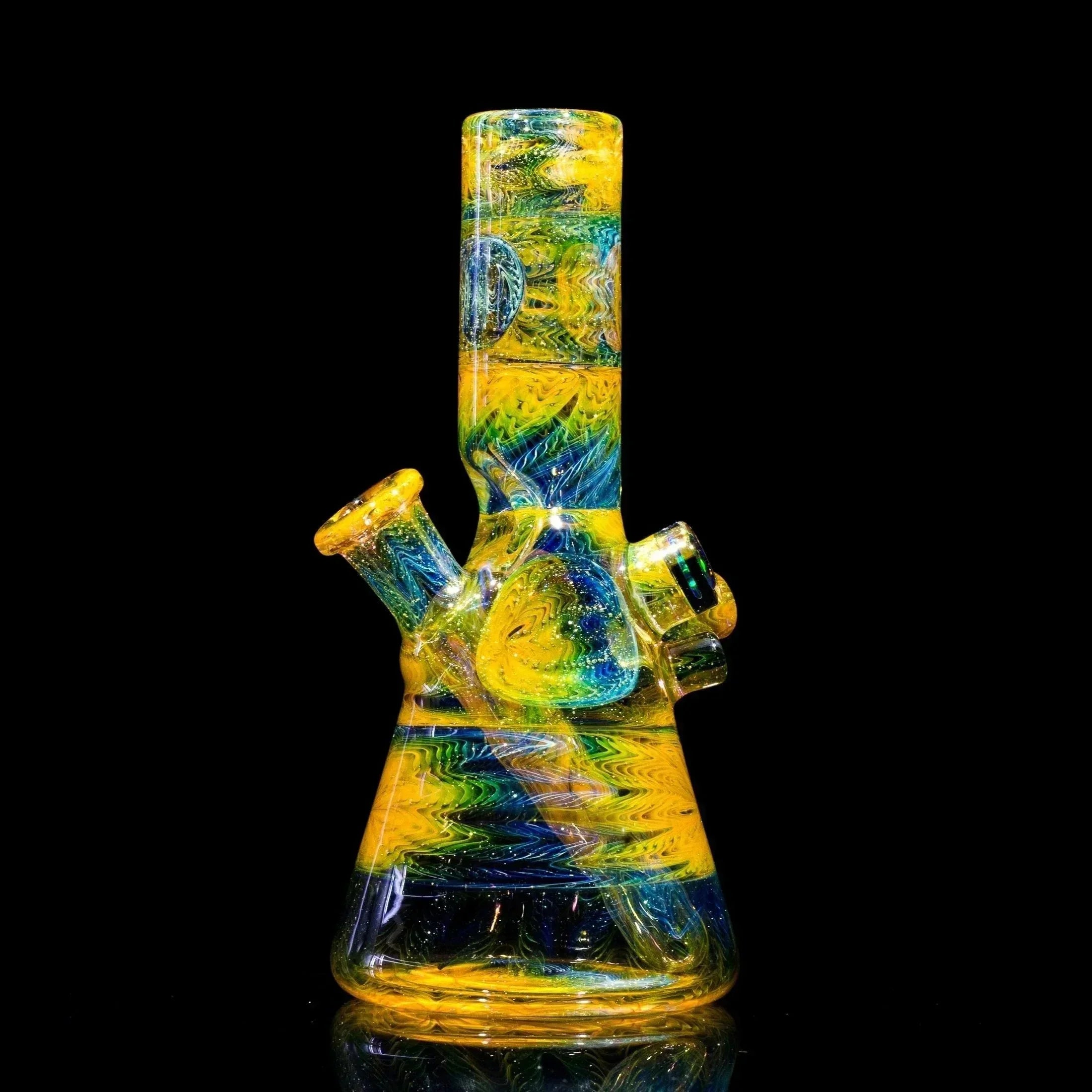 Vibrant yellow, green, and blue swirl glass bong with glitter accents, heady glass art piece