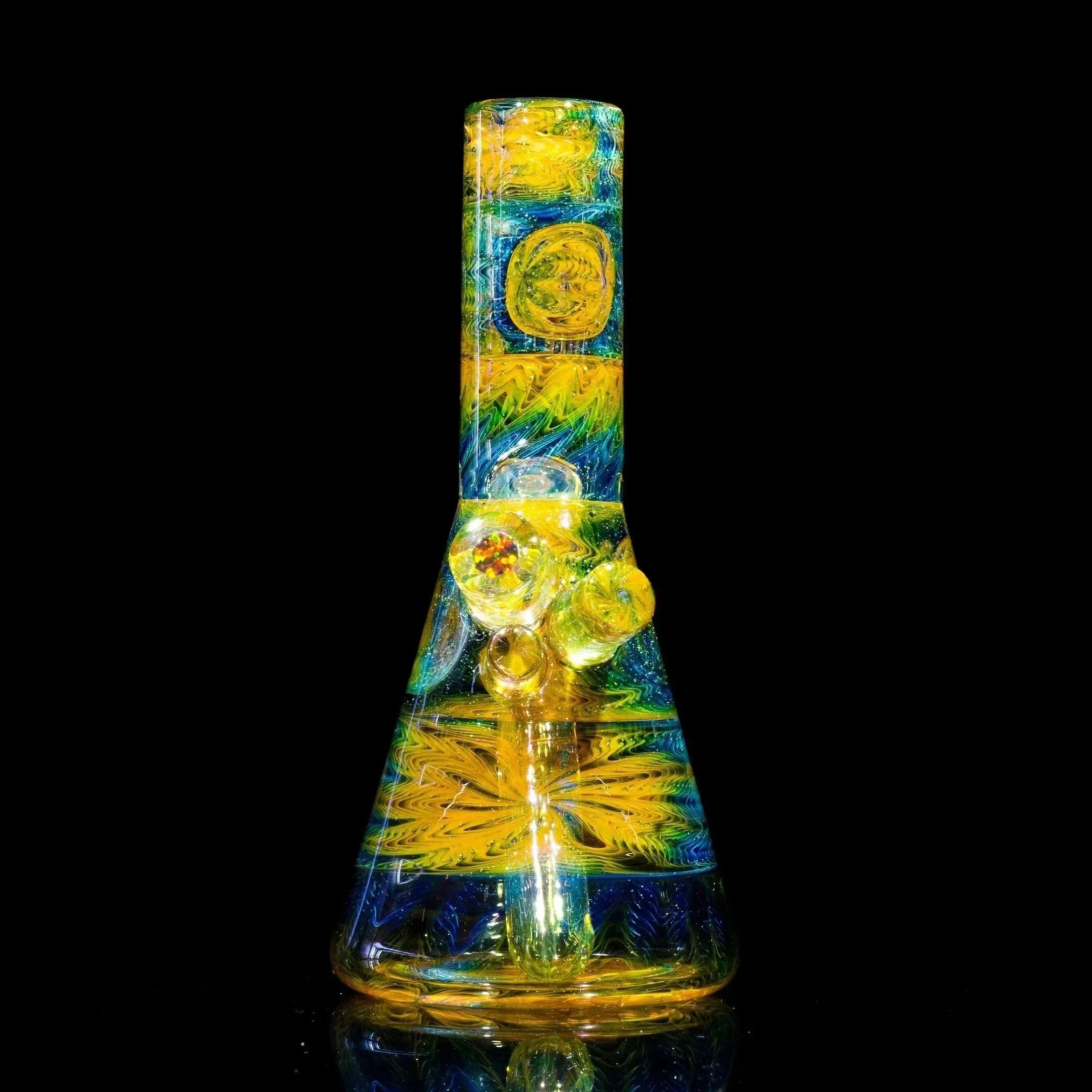 Vibrant yellow and blue heady glass bong with intricate swirls and embedded accents, set against black background.