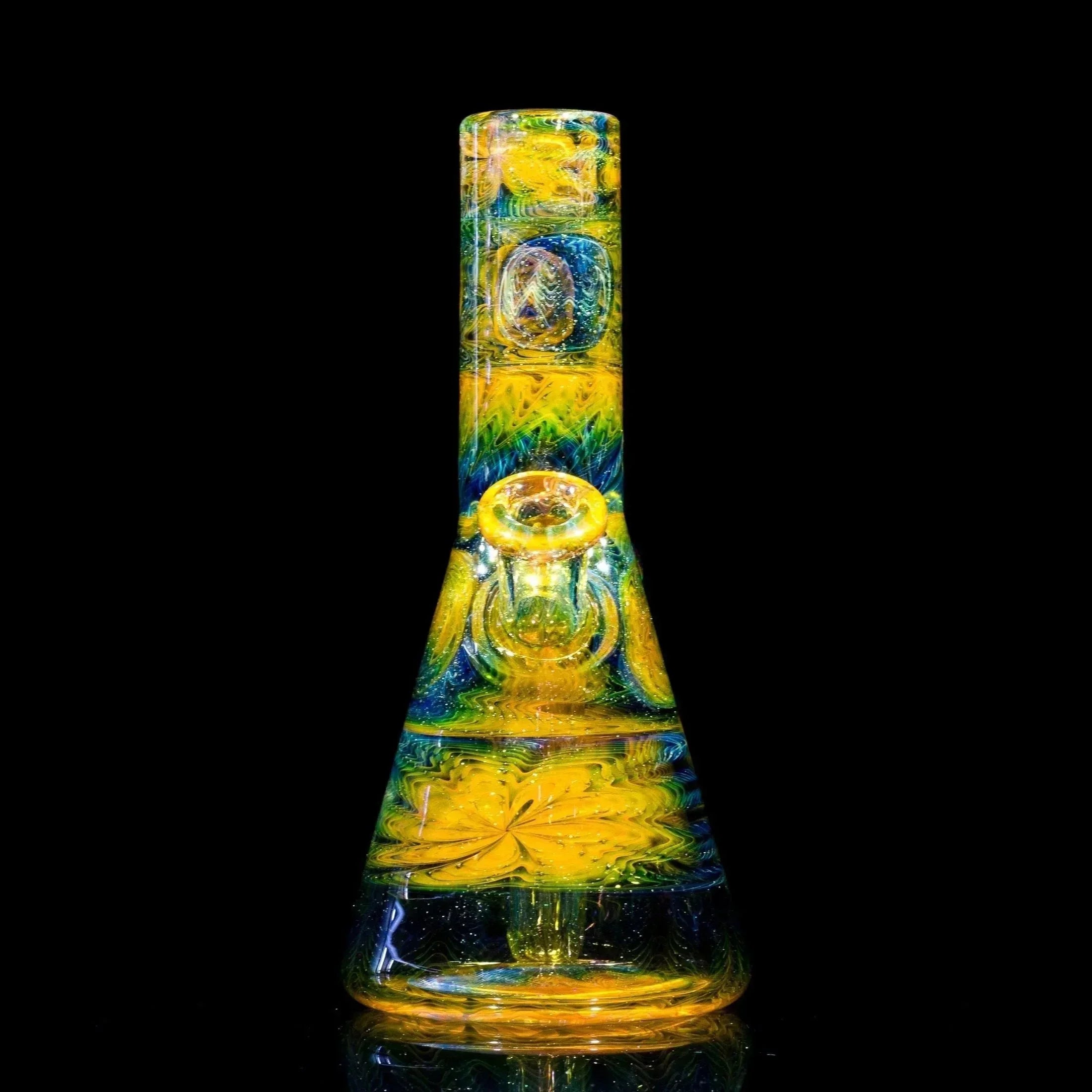Vibrant yellow and blue heady glass bong with intricate swirls and floral design on black background