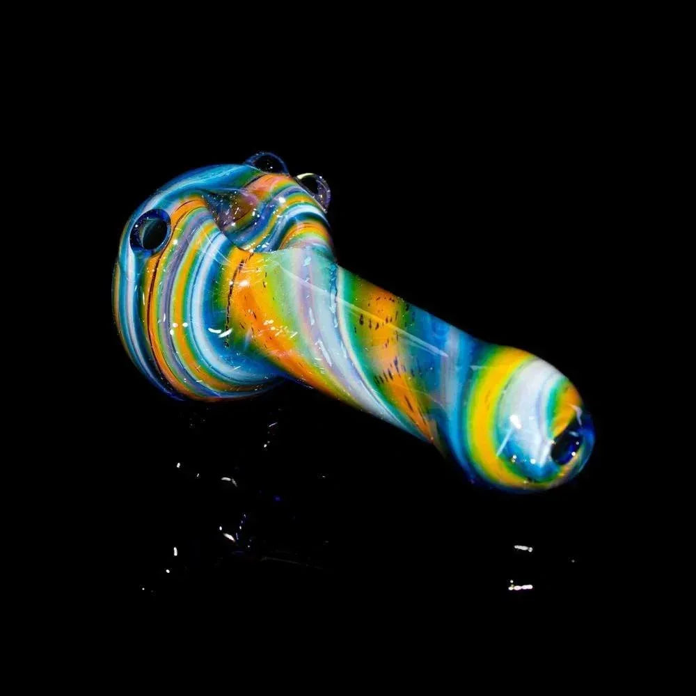 Hand-blown blue fumed glass spoon pipe with vibrant swirl patterns on a black background