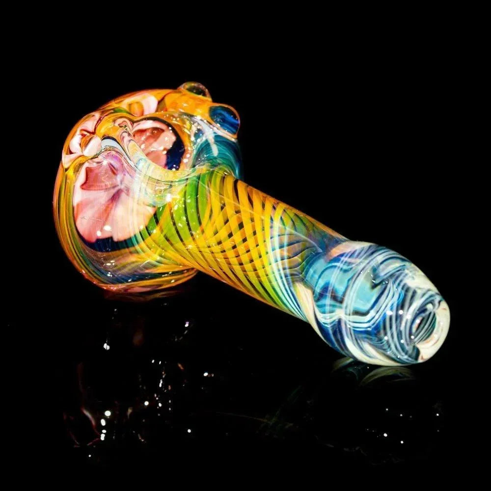 Colorful glass spoon pipe with pink flower design and fumed swirl patterns on black background