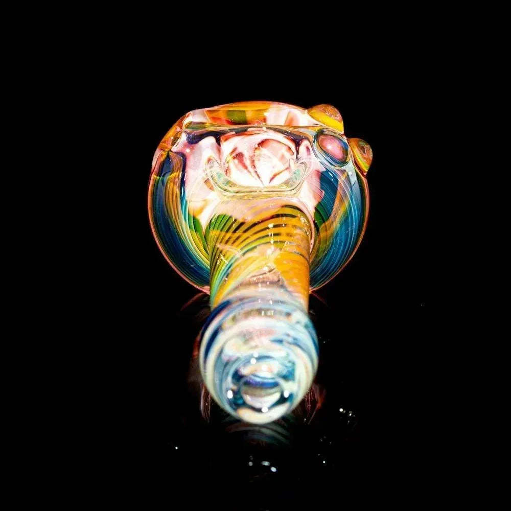 Colorful fumed glass spoon pipe with rosy pink flower design on a black background
