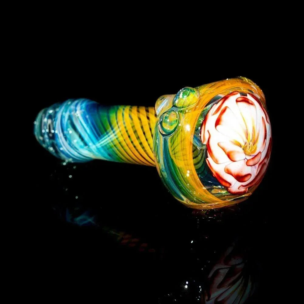 Colorful glass hand pipe with rosy pink flower design and fumed accents on a black background