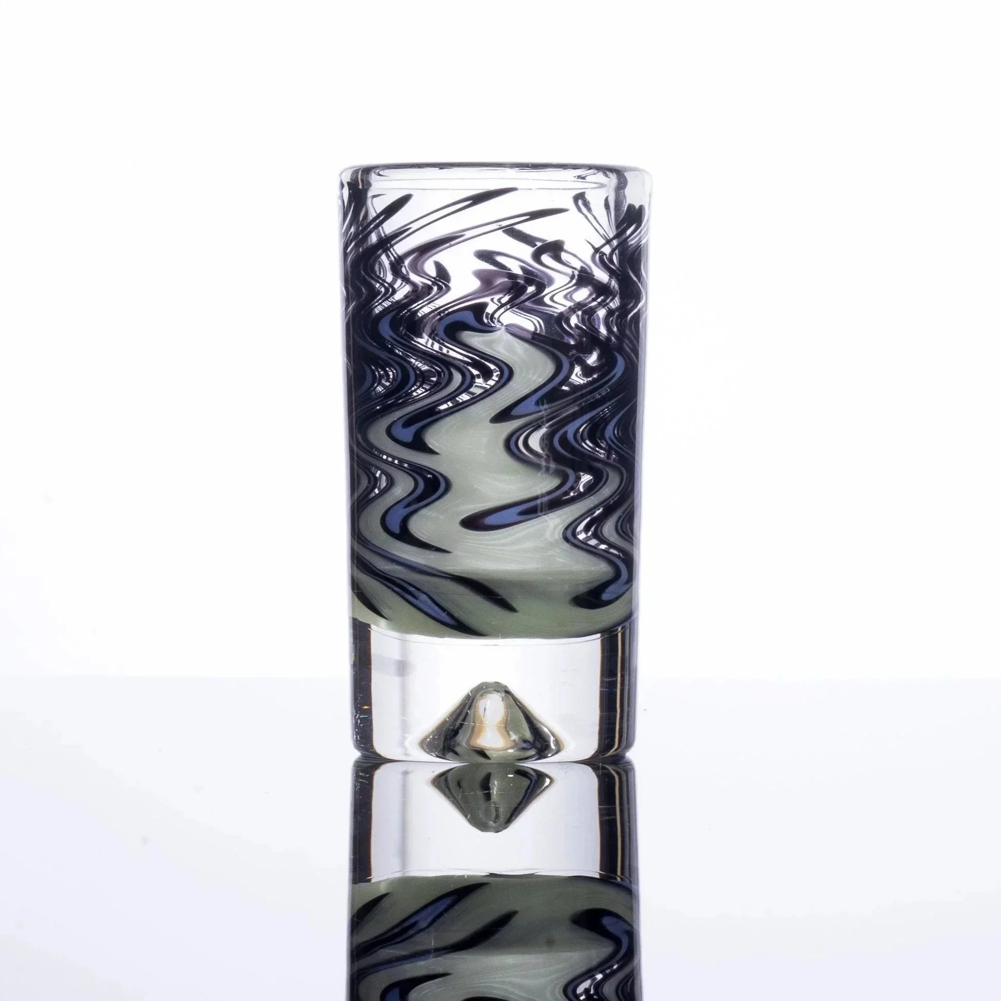 Handblown glass pipe with swirling black and gray patterns, clear base, and diamond foot on reflective surface