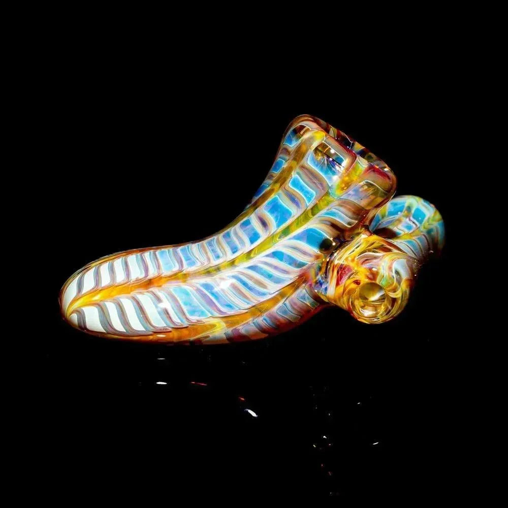 Colorful amber and purple hand-blown glass pipe with twisted pattern on black background