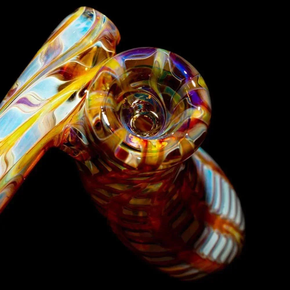 Colorful hand-blown glass pipe with amber and purple swirl design on black background