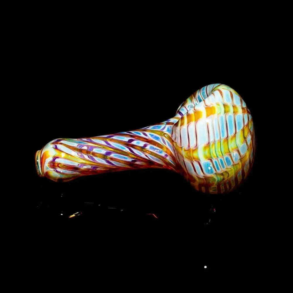 Colorful amber and purple glass hand pipe with twisted and raked patterns on black background.