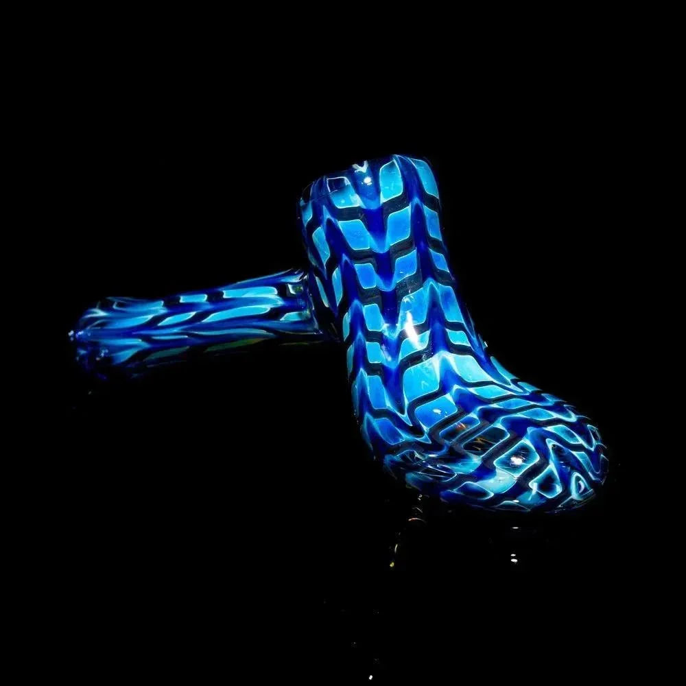 Blue glass hand pipe with striking zigzag pattern on black background