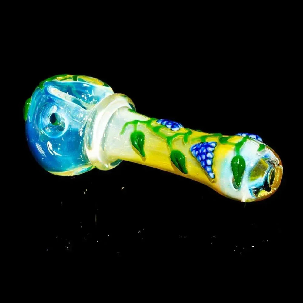 Hand-blown glass pipe with blue floral design and leaf accents on a black background