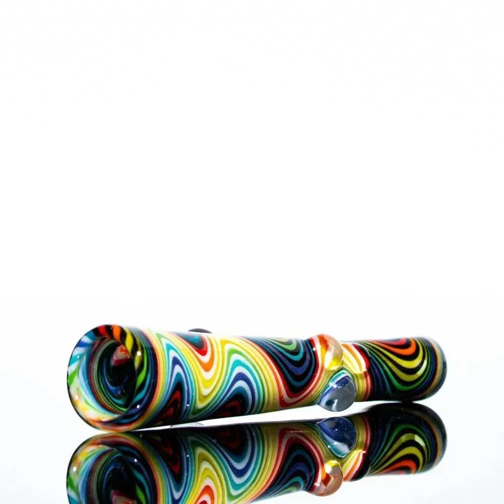 Colorful rainbow wig wag glass onie pipe with black accents on a reflective surface