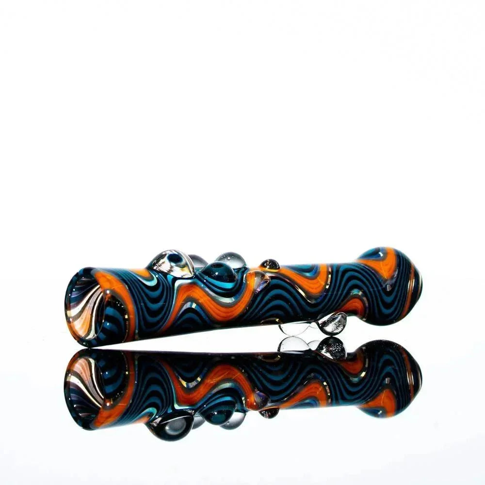 Black, blue, and orange wig wag glass chillum with decorative glass marbles on white background