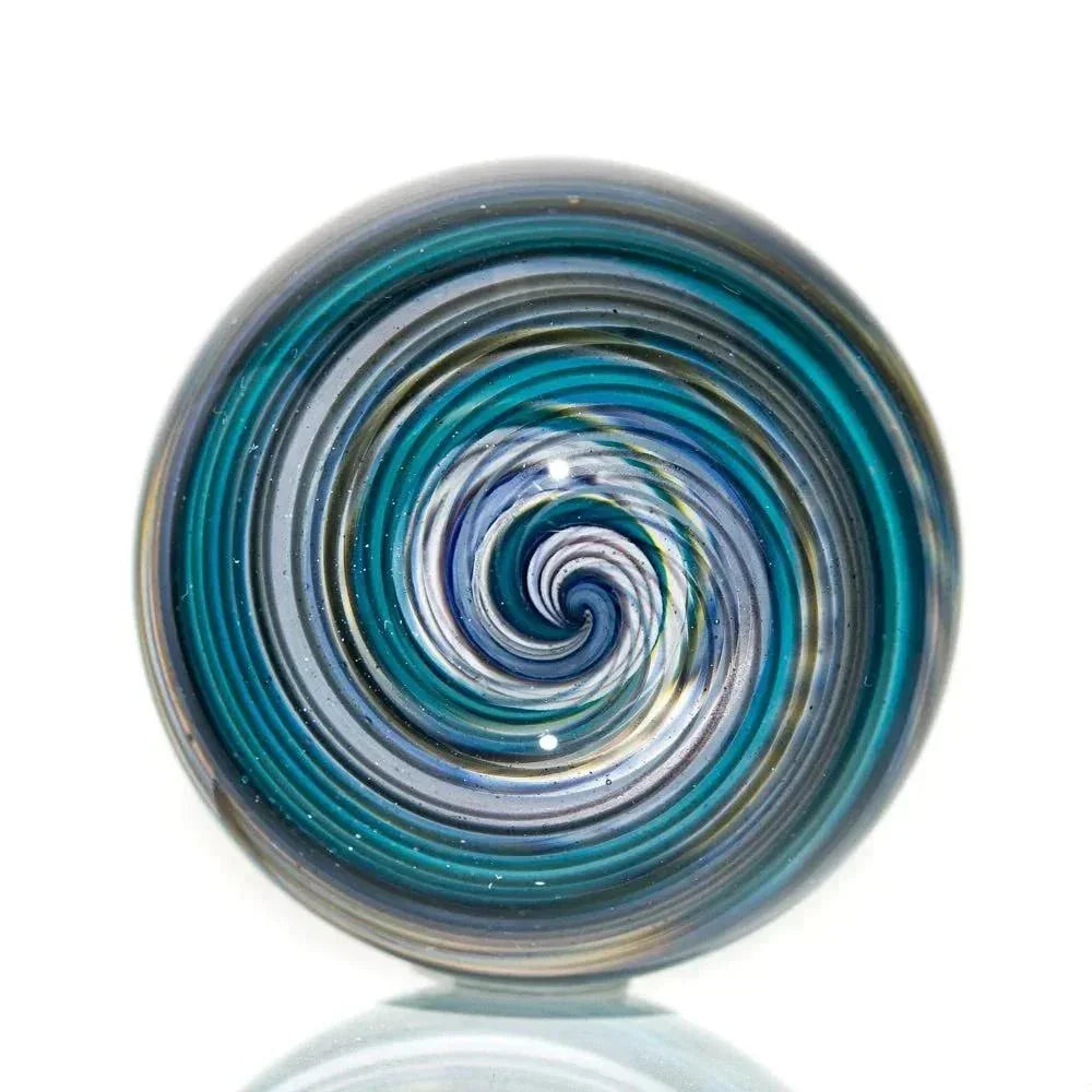 Handcrafted glass marble with blue and gray swirling linework design on white background