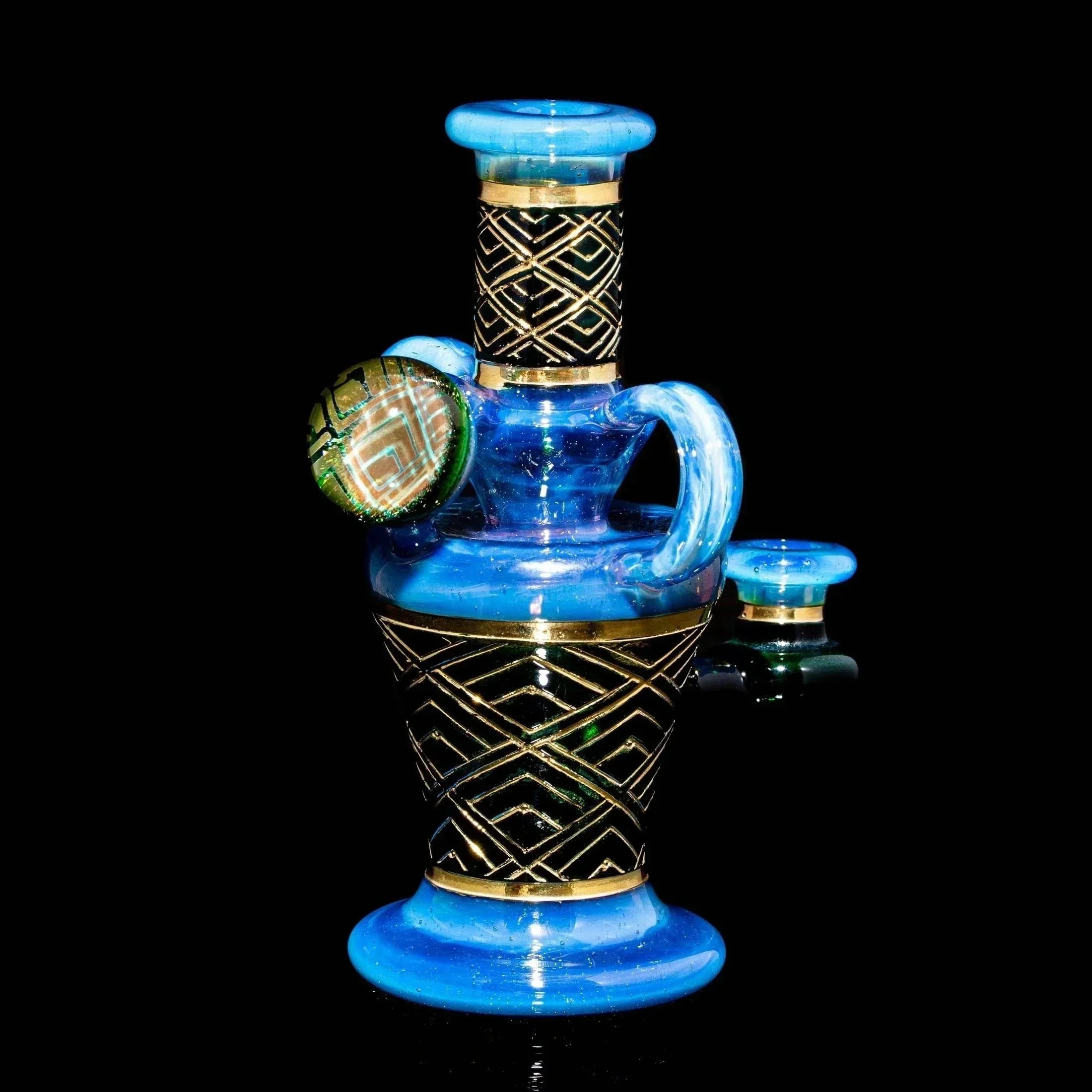 Blue art deco glass water pipe with gold geometric accents on black background