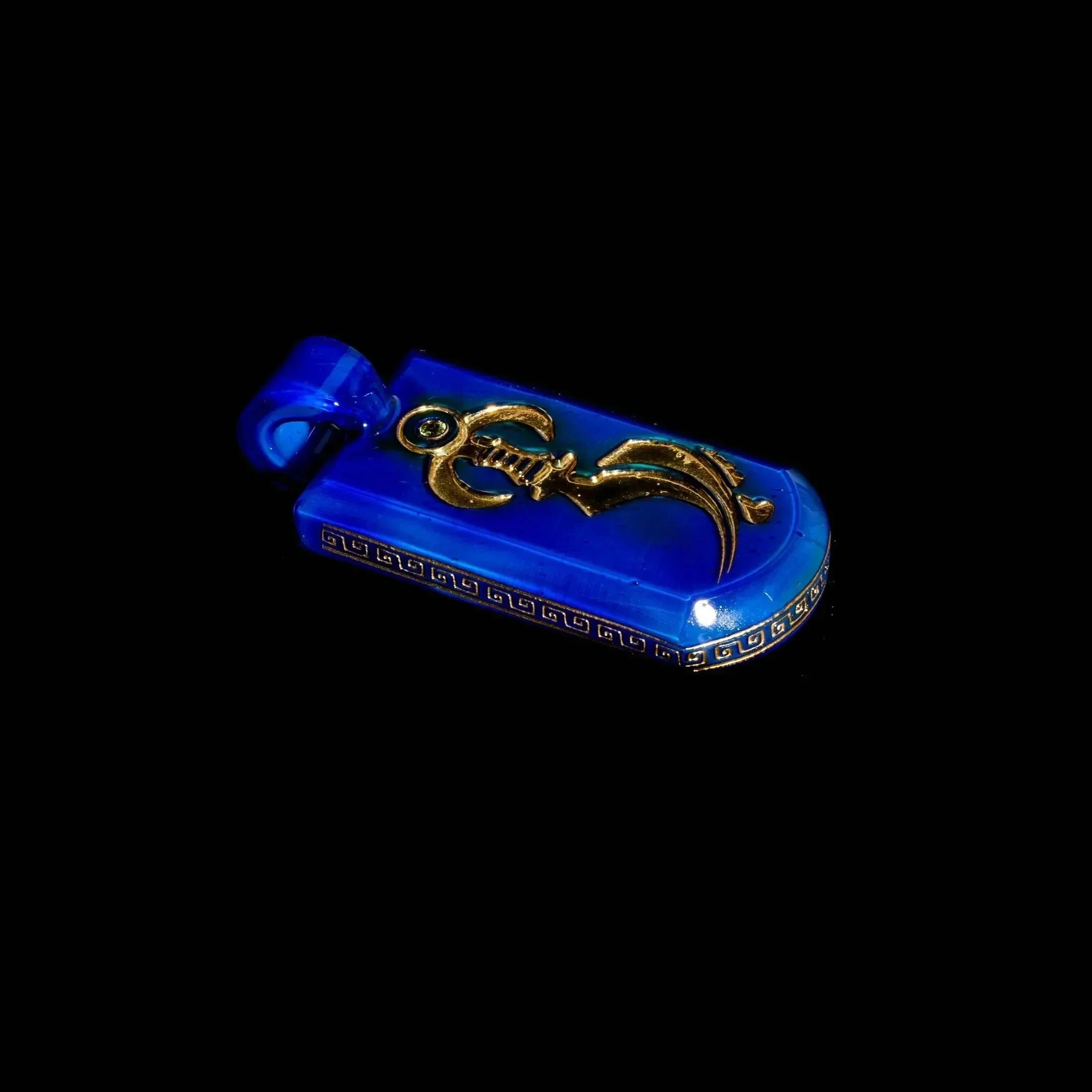 Blue glass pendant with gold dagger design and intricate border on a black background