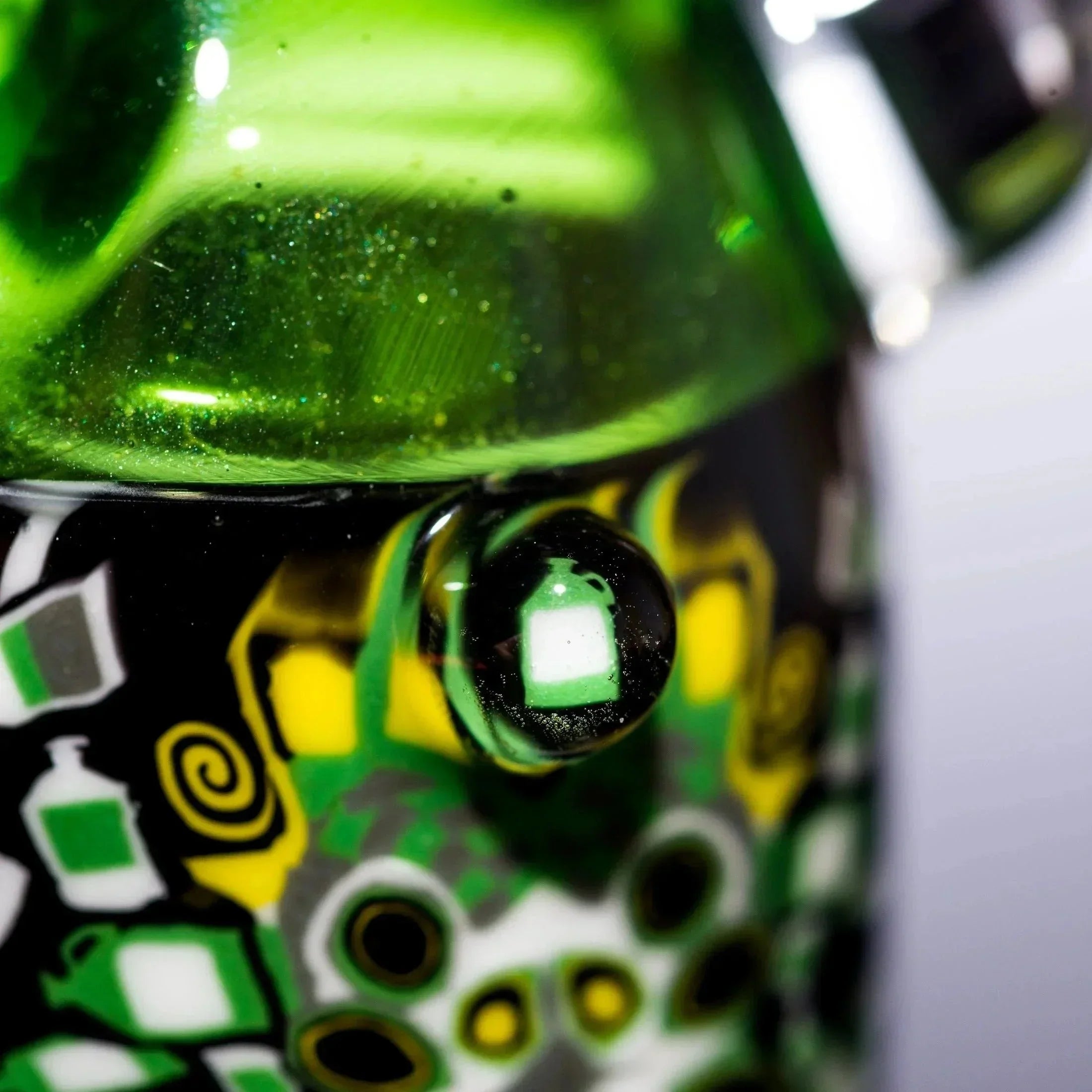 Vibrant green heady glass pipe with glitter, intricate yellow and black patterns, and a glossy finish.