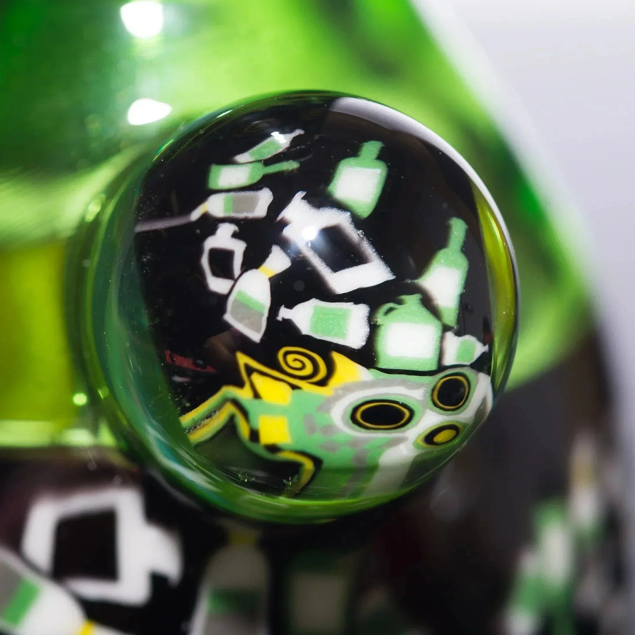 Vibrant green heady glass pipe with intricate black, white, and yellow bottle-themed artwork