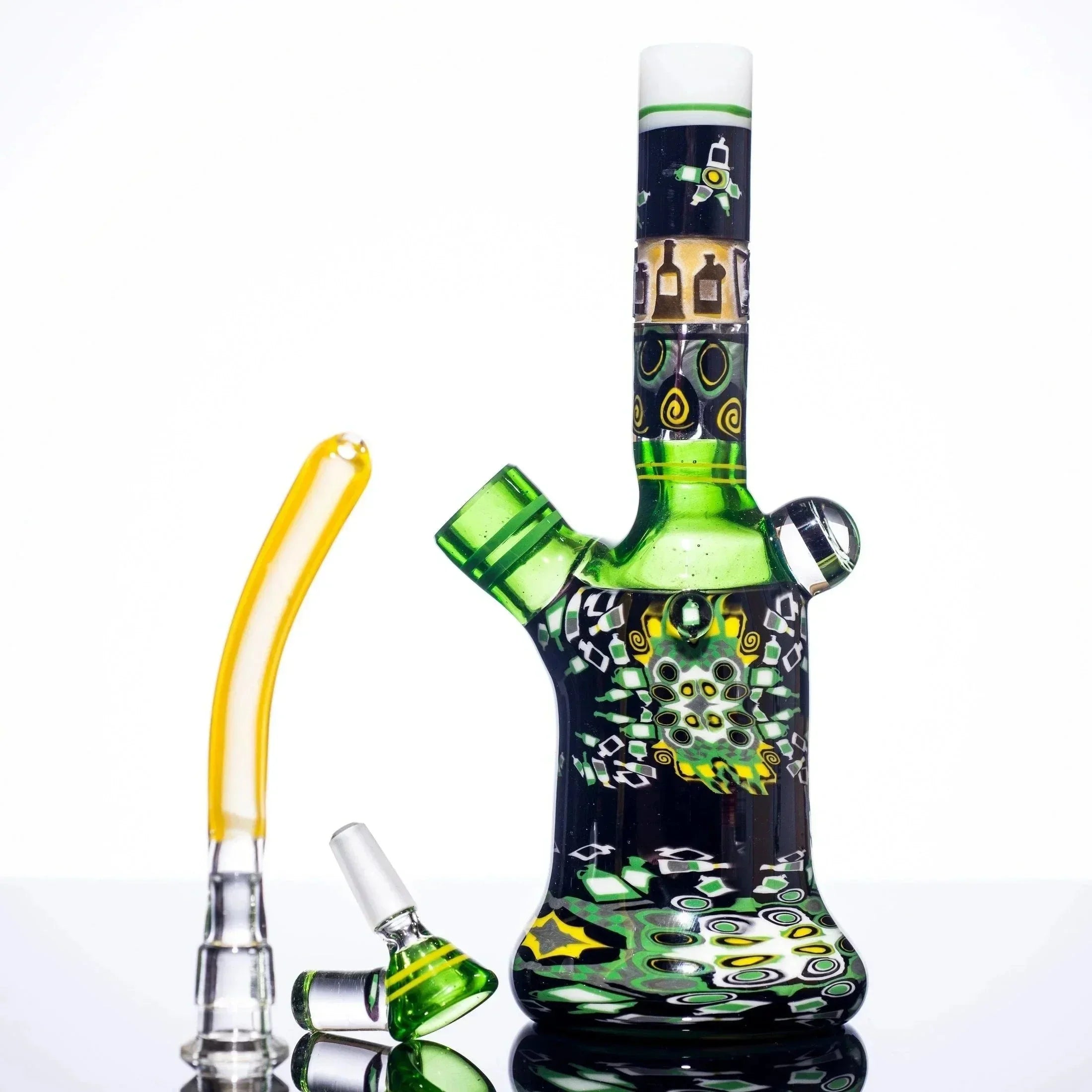 Green and black patterned glass bong with yellow accents, featuring intricate designs and a matching bowl piece.