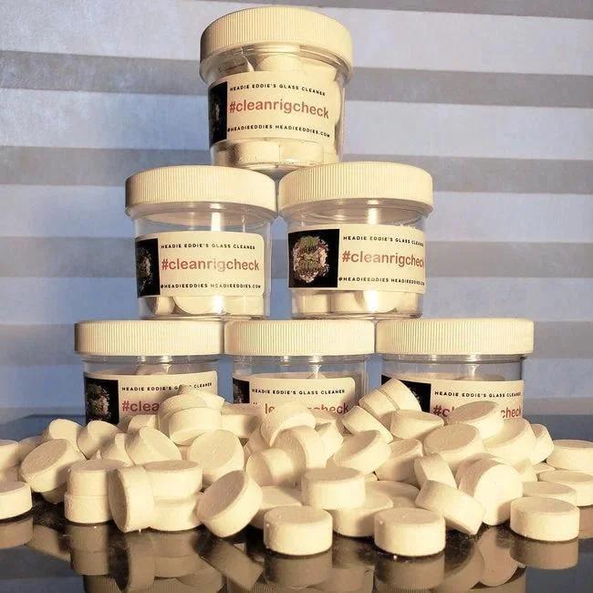 Glass cleaner jars labeled #cleanrigcheck stacked with cleaning tablets in front