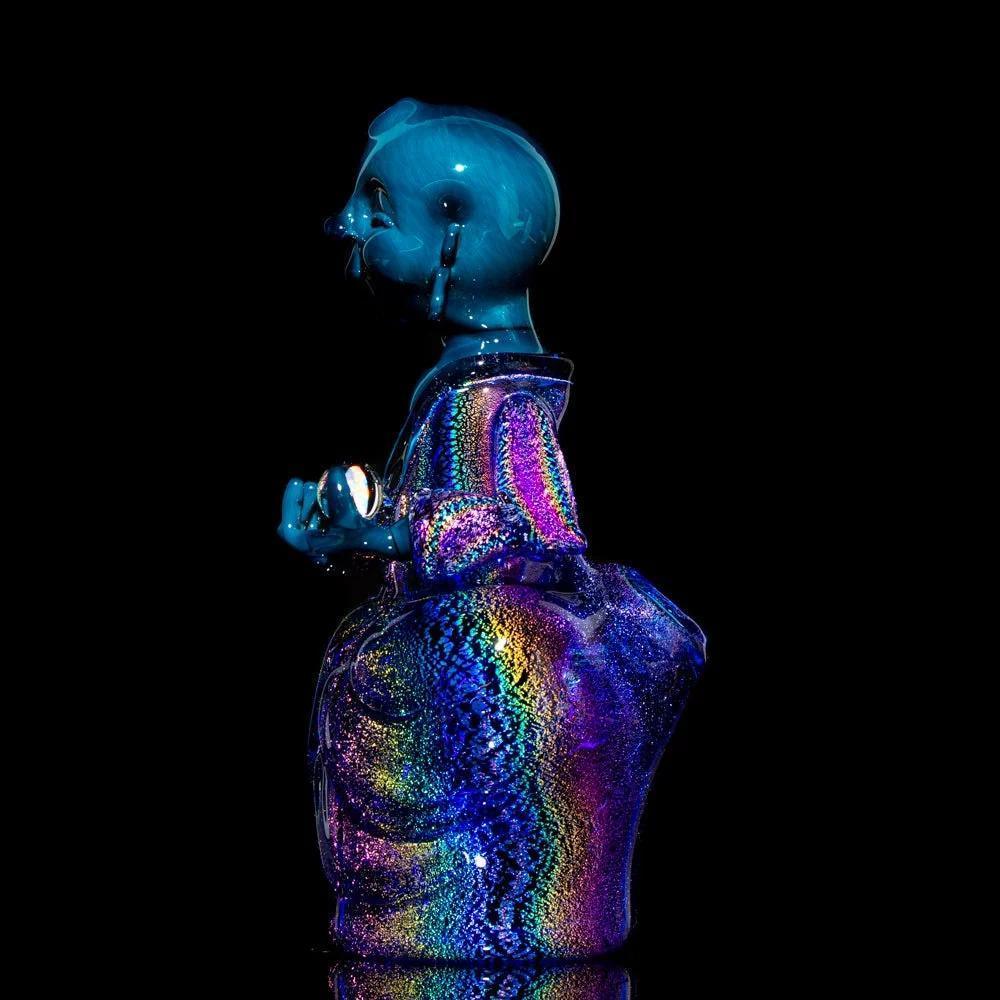 Heady glass art sculpture of a blue figure with colorful iridescent detailing, black background