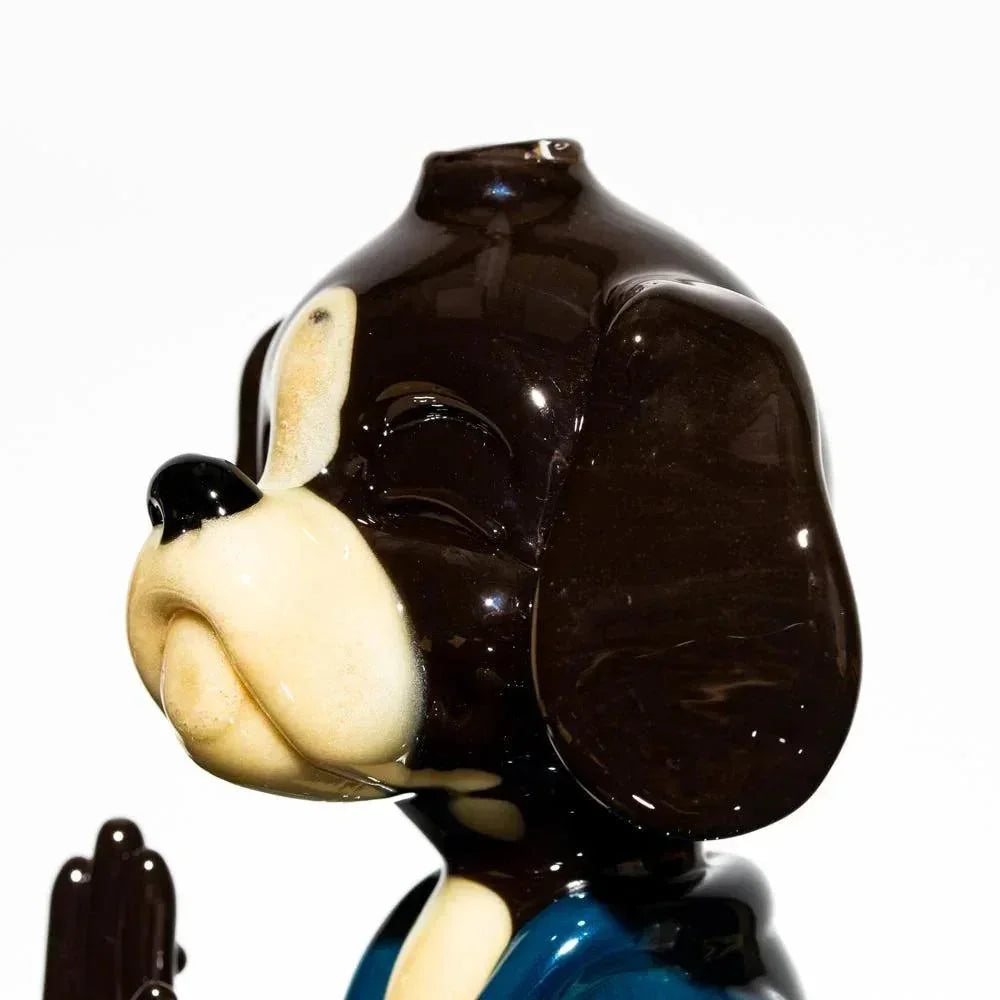 Heady glass dog sculpture in meditation pose, brown and cream colors, close-up view
