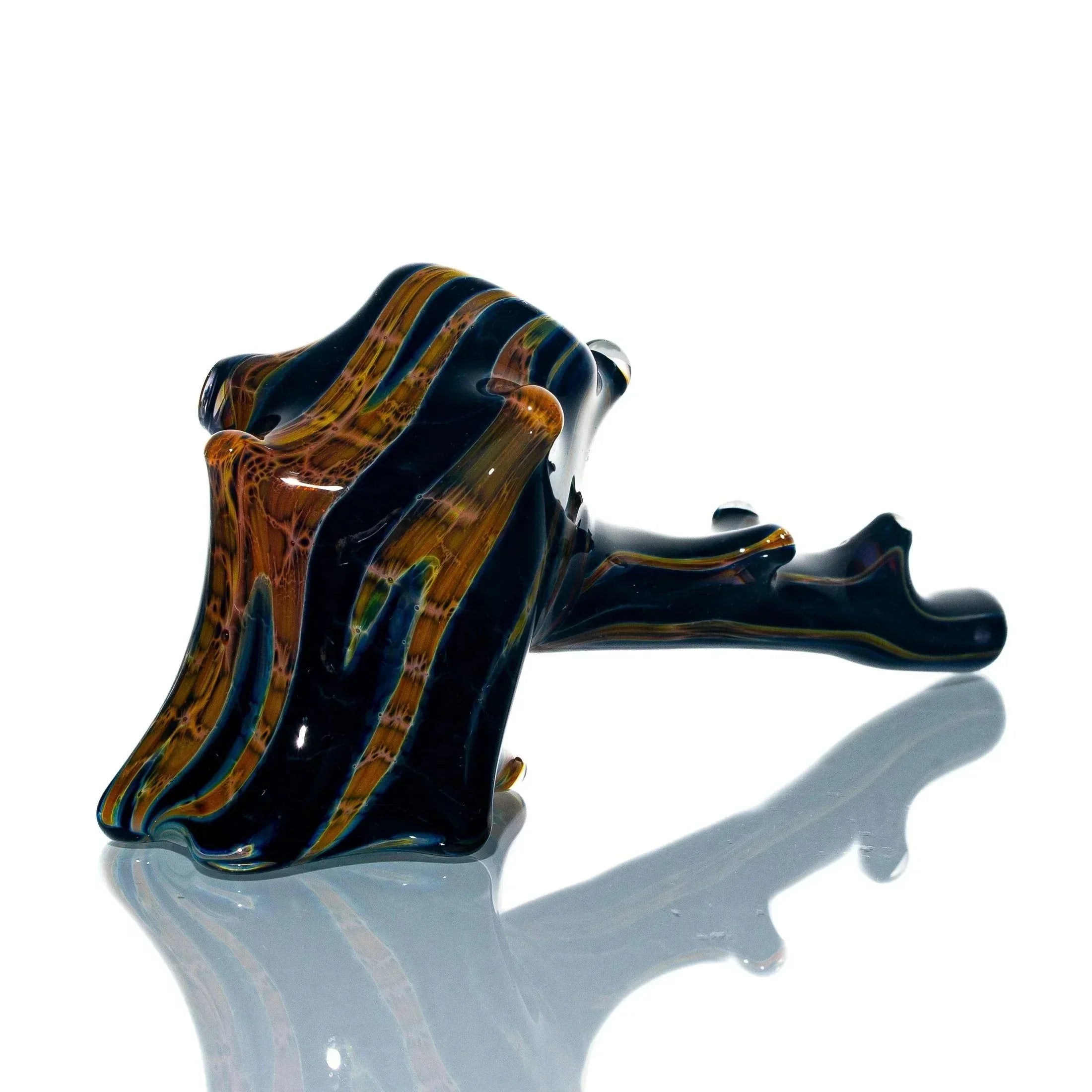 Handblown glass pipe with burnt hickory wood pattern on reflective white surface
