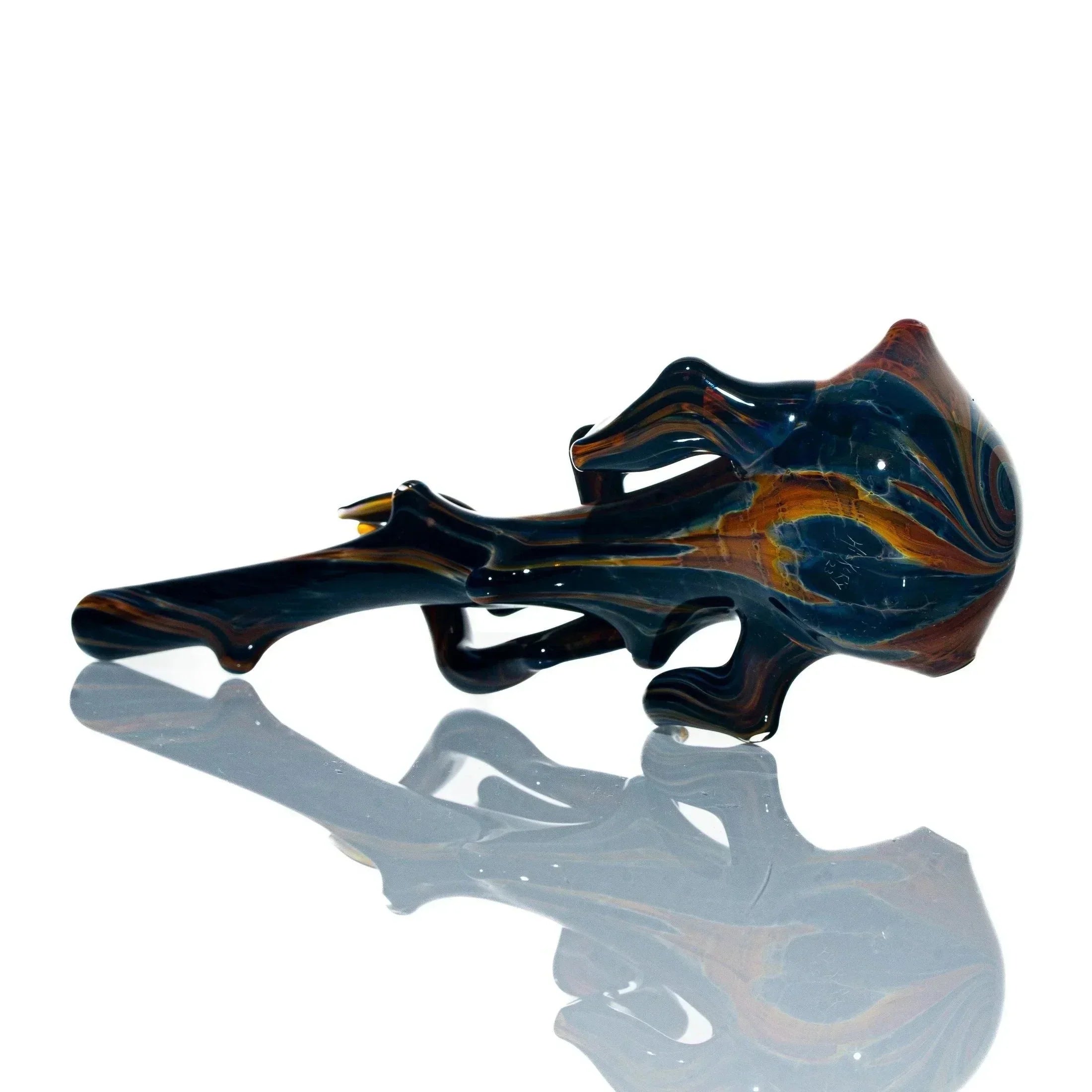 Artistic glass spoon pipe with burnt branch design and swirling colors on white background