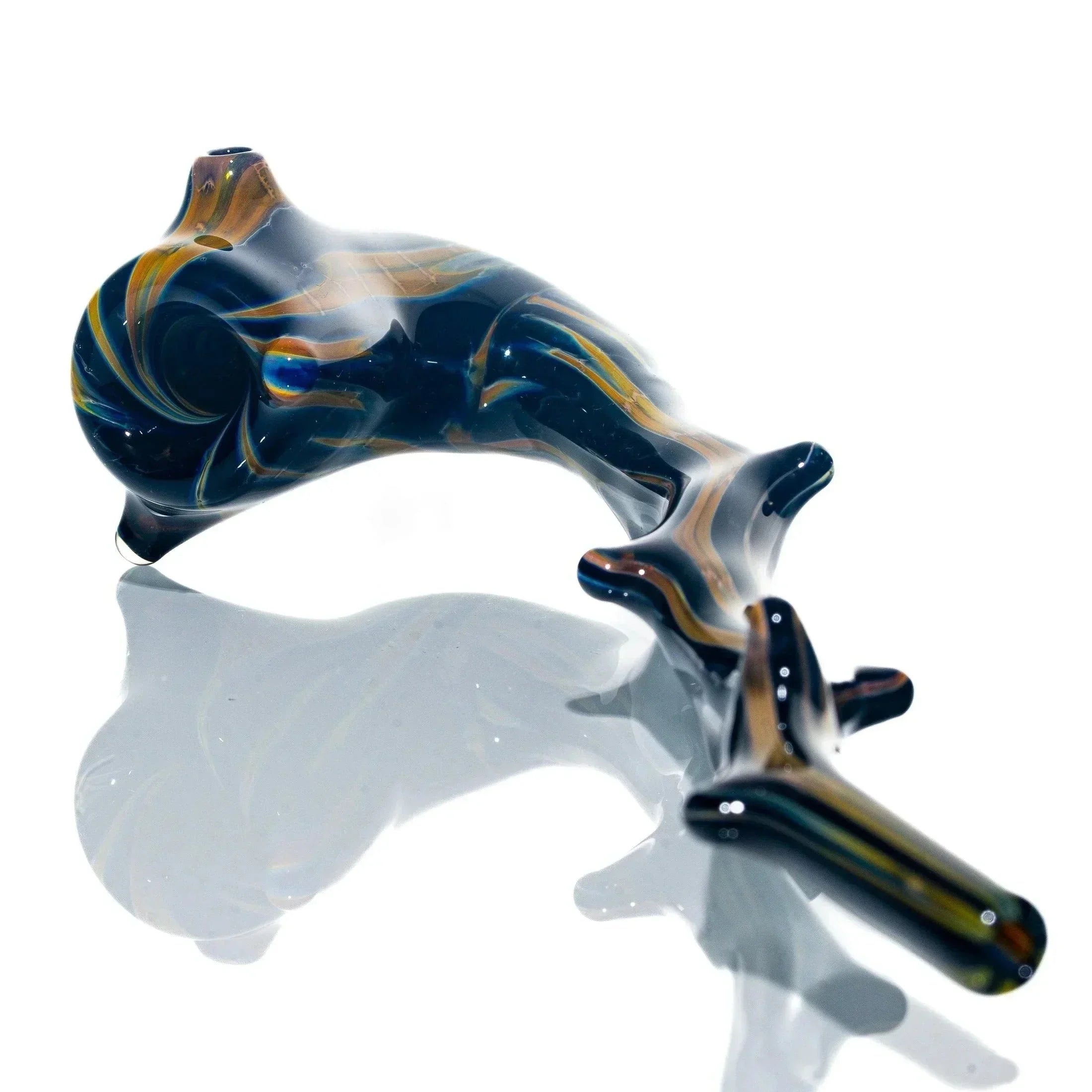Hand-blown glass pipe with swirling brown and blue patterns on a reflective surface.