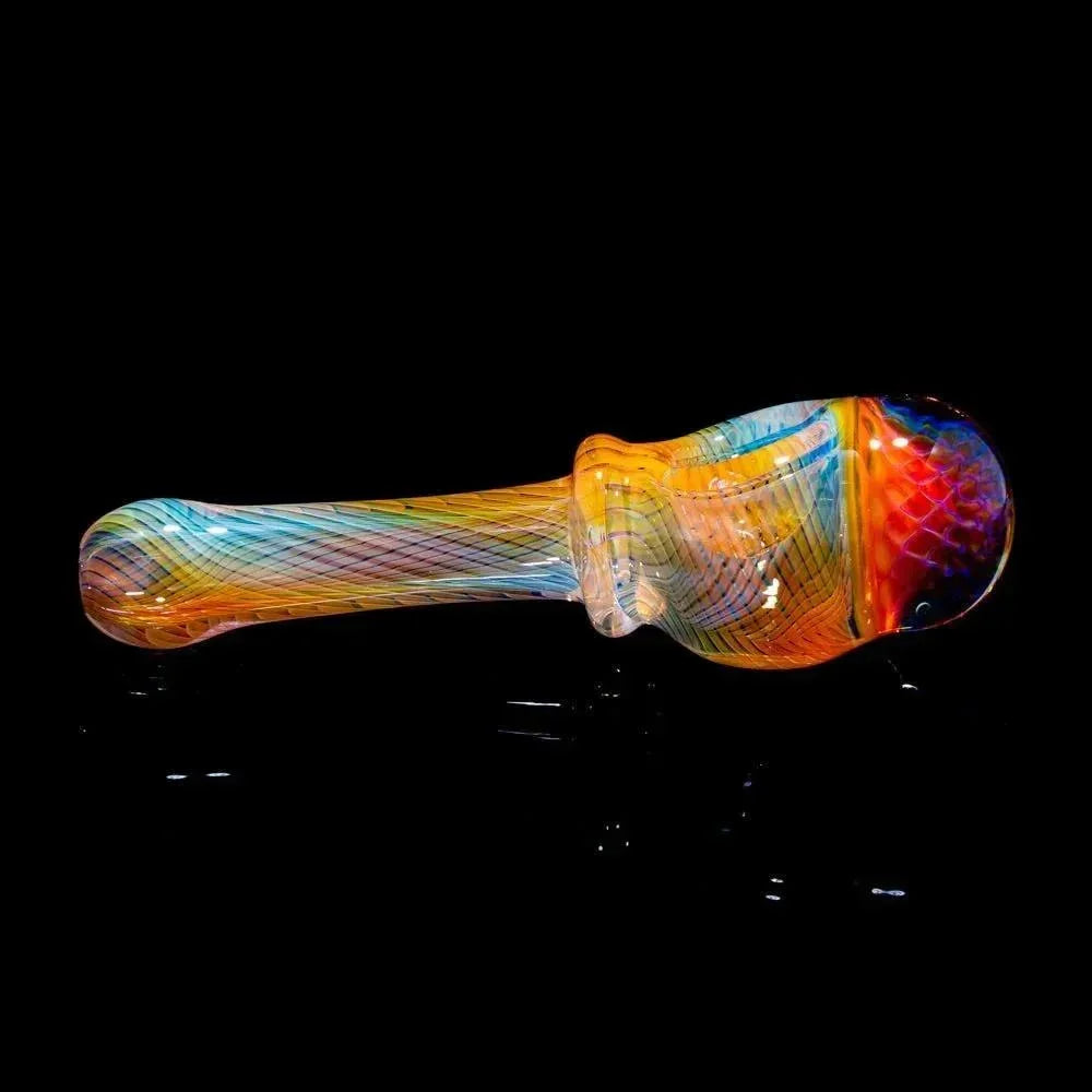 Colorful glass pipe with honeycomb linework design on a black background