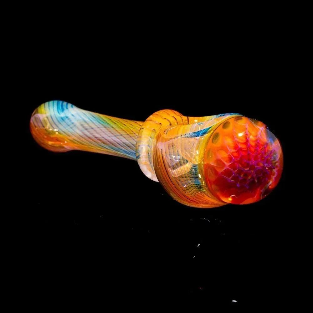 Colorful glass pipe with honeycomb pattern and linework on black background