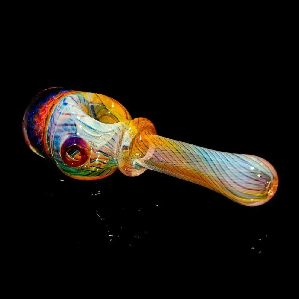 Colorful glass spoon pipe with honeycomb and linework design on black background