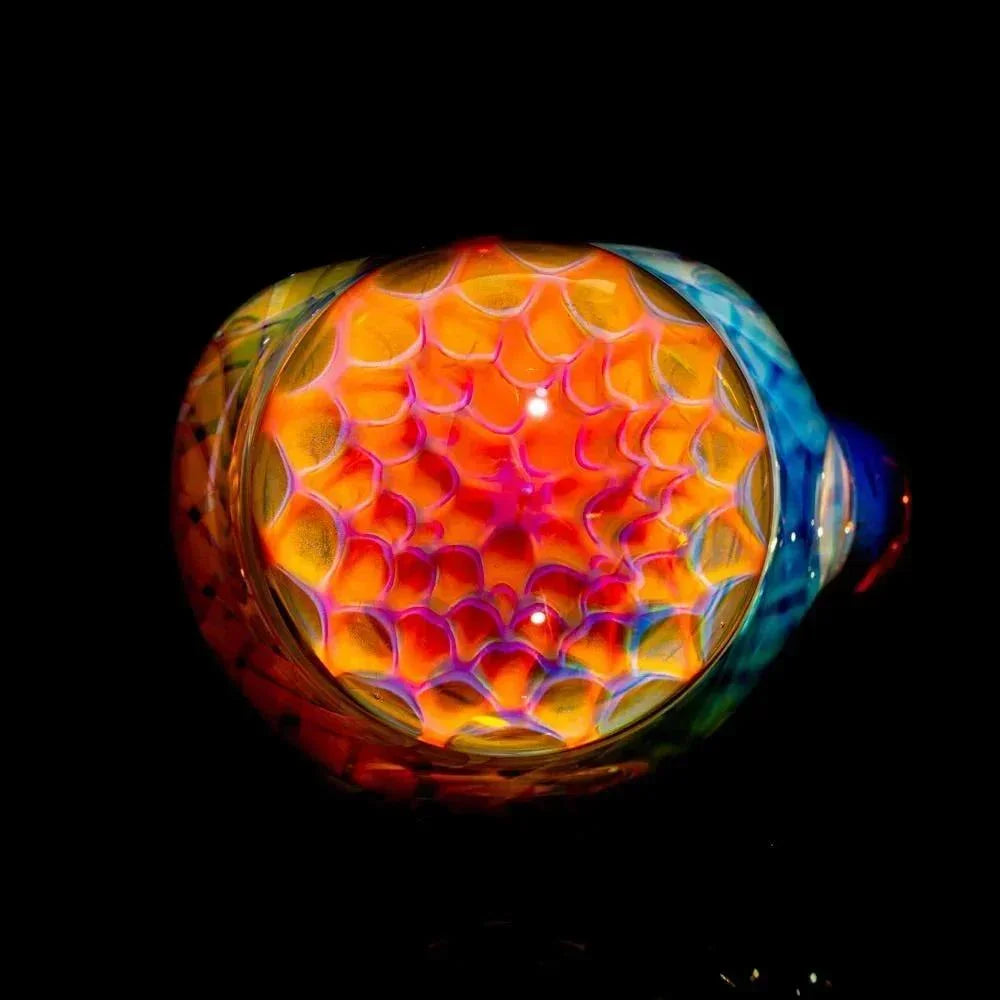 Colorful honeycomb glass pipe with intricate linework and vibrant patterns on black background.