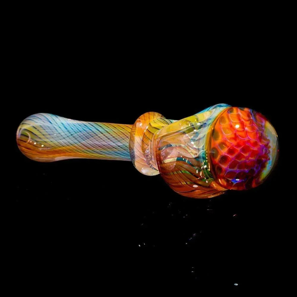 Colorful honeycomb glass spoon pipe with intricate linework on a black background