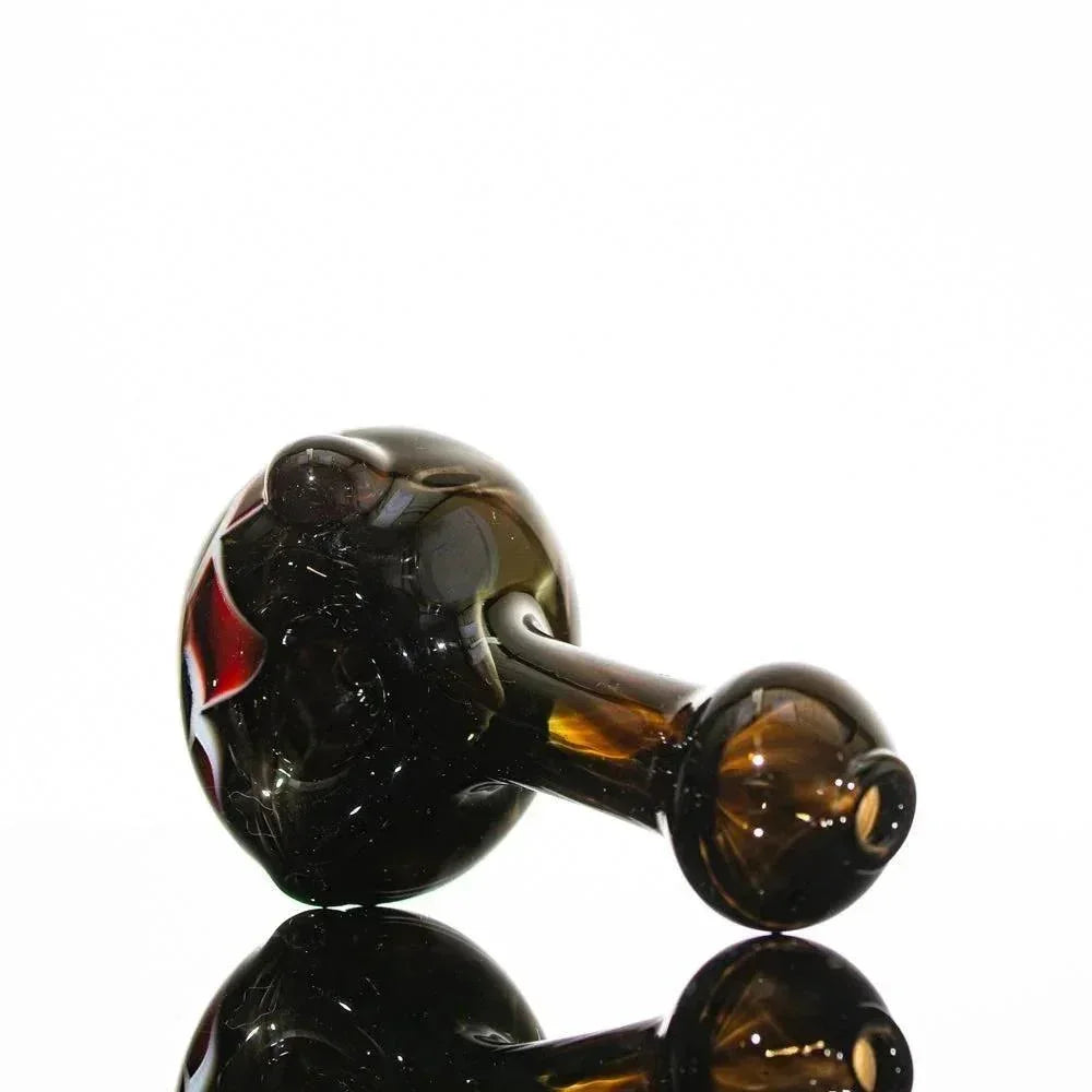 Handblown glass pipe with black and red swirls, amber stem, reflective surface