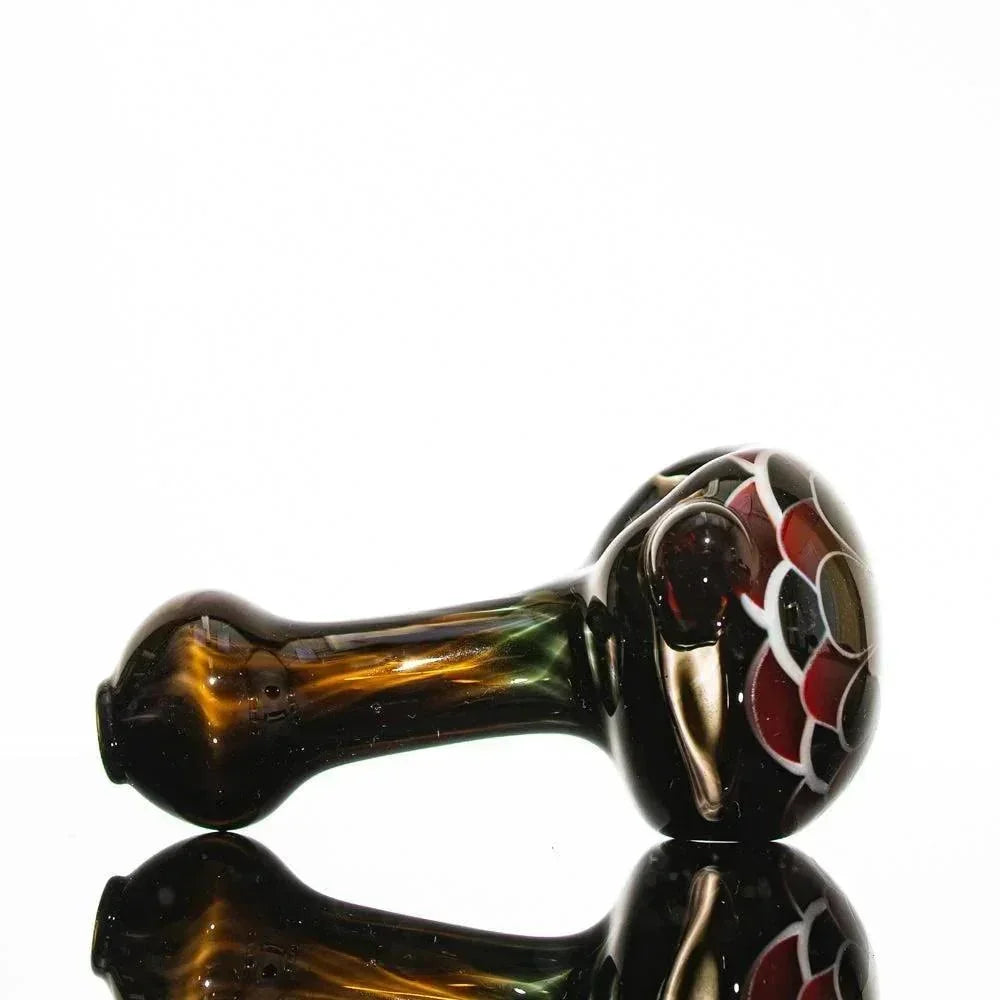 Handblown glass pipe with red and black floral design, amber stem, reflective surface