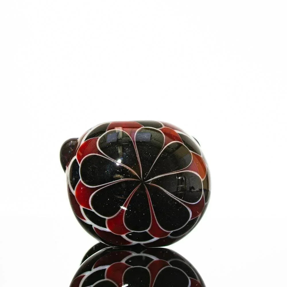 Black and red glass pipe with floral design, reflective surface